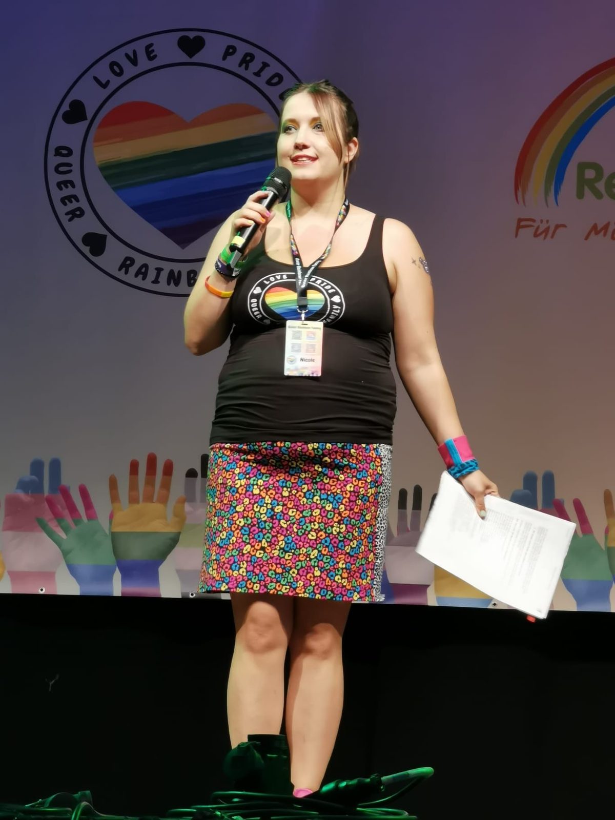 Nicole auf der Bühne bei einem Vortrag zu Polyamorie und queeren Themen